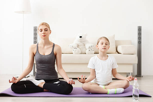 istock Mother and daughter doing yoga together 541291998