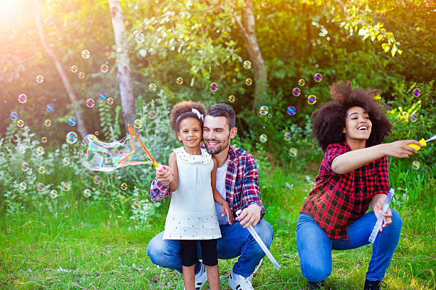 istock Happy family playing soap bubbles in park. 541292832
