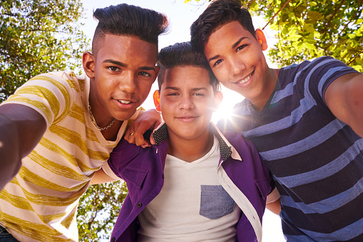 Youth culture, young people, group of male friends, multi-ethnic teens outdoors, teenagers together in park. Portrait of happy boys smiling, kids looking at camera. Slow motion
