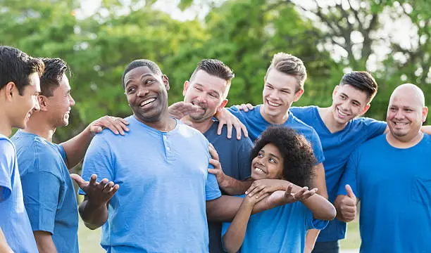 Photo of Black man in group getting pat on back