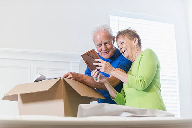 Senior couple packing box, looking at picture frame