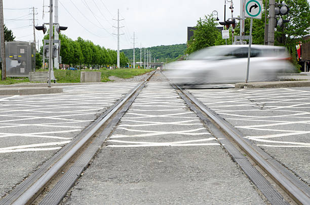 Long exposure of car passing over railroad crossing Long exposure of car passing over railroad crossing sherbrooke quebec stock pictures, royalty-free photos & images