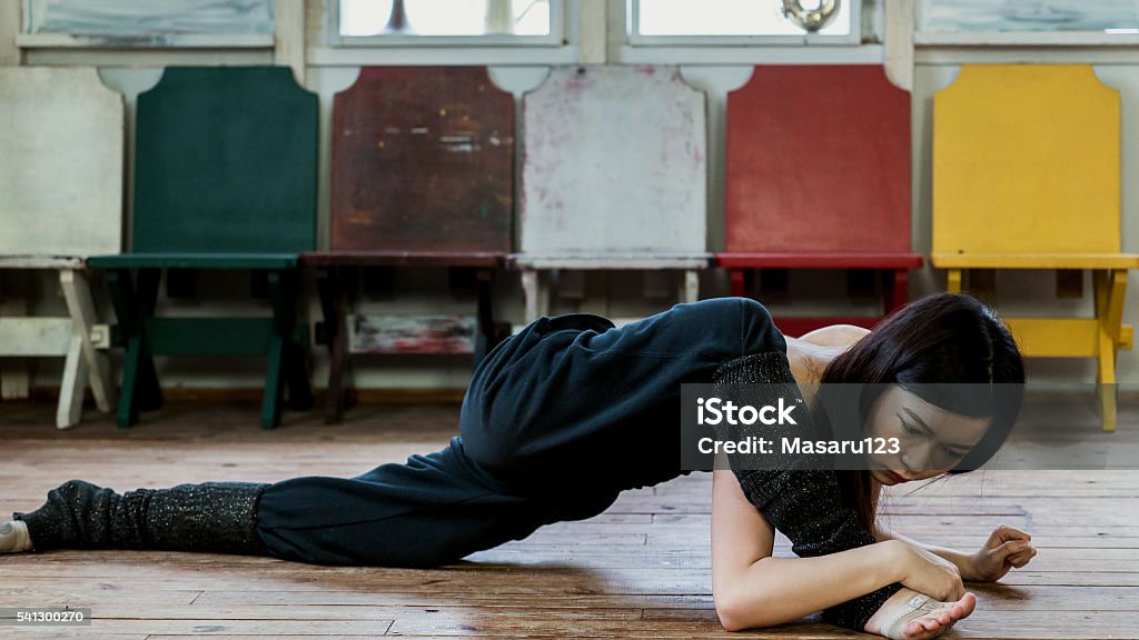 Young woman stretching on wooden floor A young woman is stretching on wooden floor. 20-29 Years Stock Photo