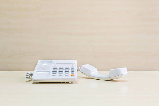 istock Closeup white office phone on blurred wooden desk and wall 541302274