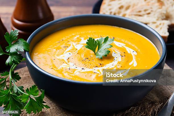 Pumpkin And Carrot Soup With Cream And Parsley Stock Photo - Download Image Now - Soup, Pumpkin Soup, Pumpkin