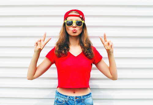 Fashion pretty cool woman in sunglasses and red t-shirt over white background