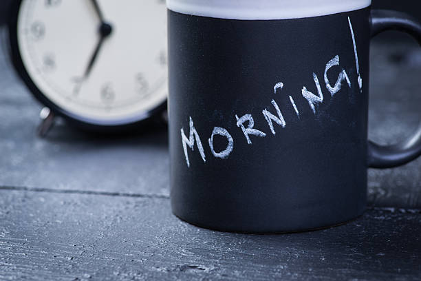 istock Black tea cup with alarm clock on wooden table 541311218