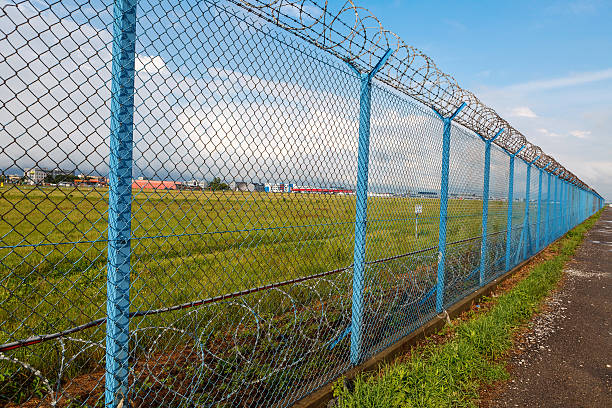 istock Barbed wire fence of a restricted area under blue sky 541312922