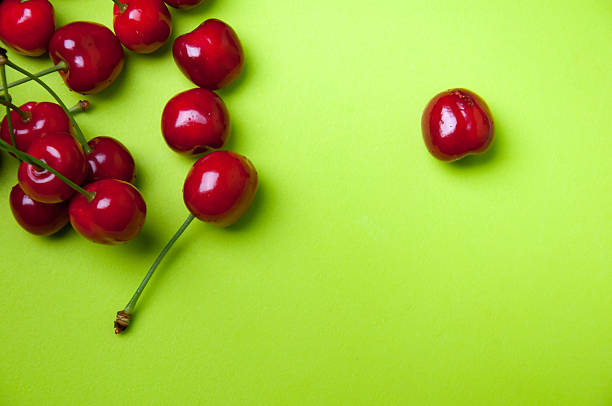 istock Red sweet cherries on green background 541313054
