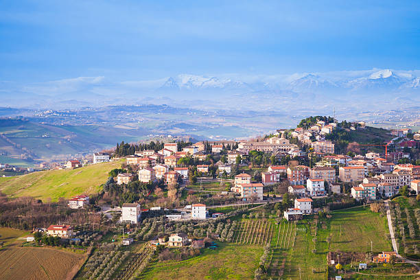 Bright rural panorama of Italian countryside Bright rural panorama of Italian countryside. Province of Fermo, Italy. Village on a hill under blue cloudy sky marche italy stock pictures, royalty-free photos & images