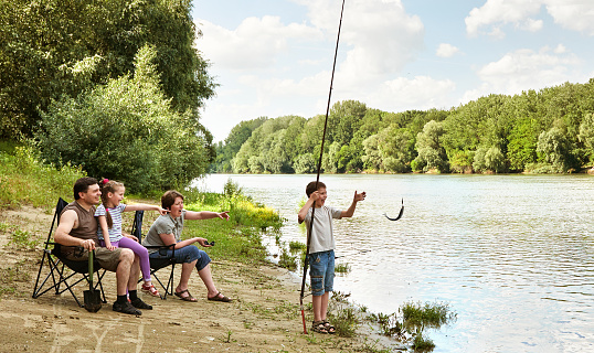 family camping and fishing, river and forest, summer season