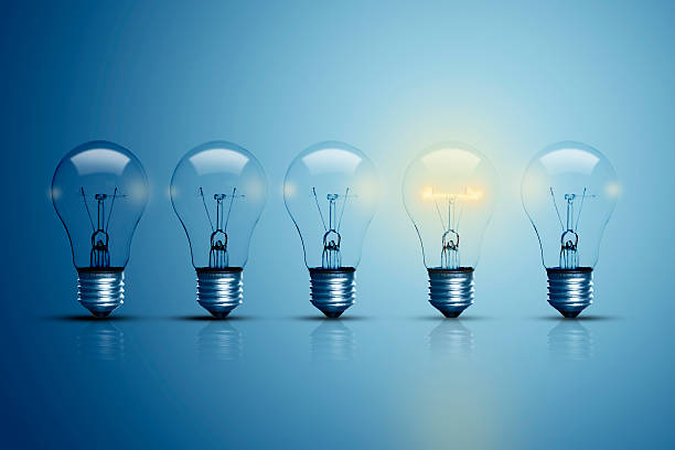 Five bulbs and one of them is glowing. stock photo
