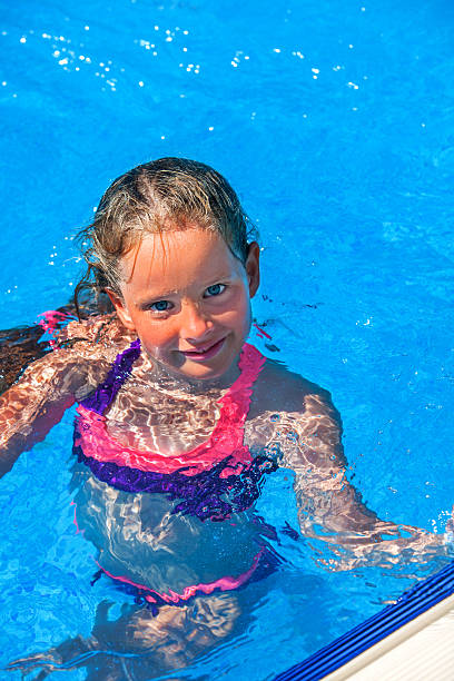 istock Child swim in blue water into swimming pool. 541574082