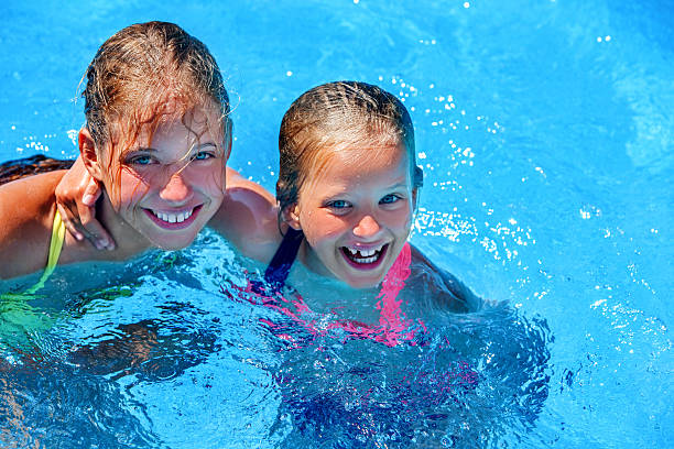 istock Two different ages children swim in swimming pool. 541574120