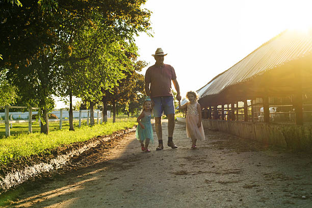 deux petites filles avec grand-père à la ferme. - casual granddaughter farmer expressing positivity photos et images de collection