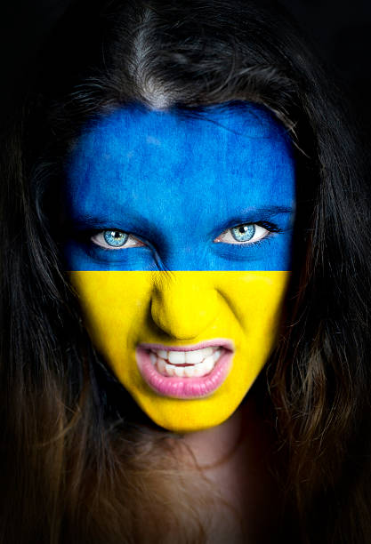 istock Soccer fan with Ukraine flag painted over face 541575610