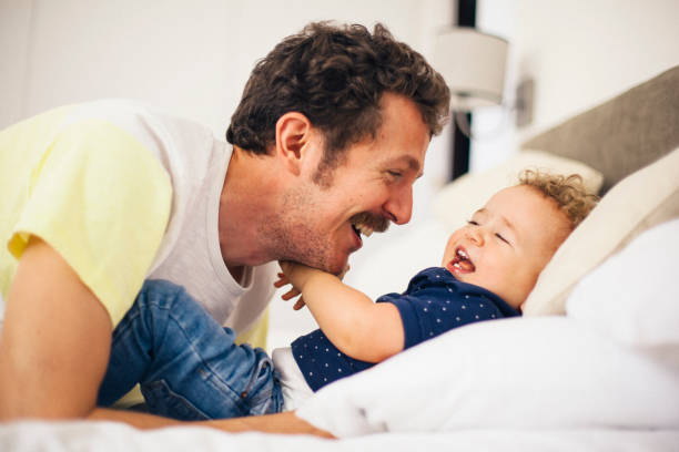 istock Father playing with baby son on bed 541575840