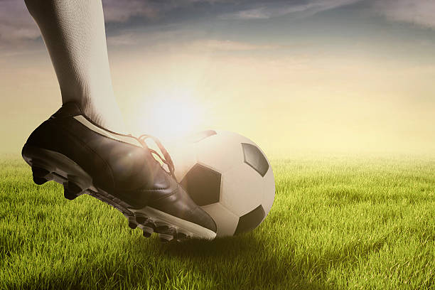 istock Foot doing free kick with ball at field 541576550