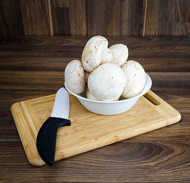 istock White mushrooms in the bowl with a ceramic knife 541577448