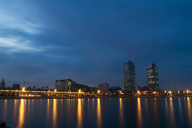 Night landscape of Barcelona beach with skyscrapers and city lights 