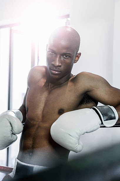 istock Male boxer leaning on ring in gym 541581910