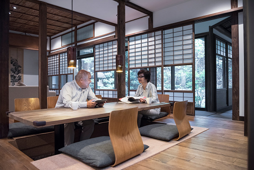 Japanese couple using digital devices at home in modern room