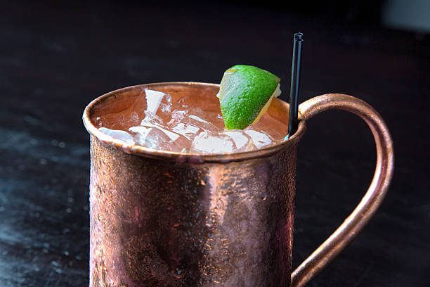 Vodka Moscow Mule Cocktail with Lime Copper Mug A cold icy Moscow Mule cocktail with vodka, ginger beer and lime in a traditional frosty copper mug moscow stock pictures, royalty-free photos & images