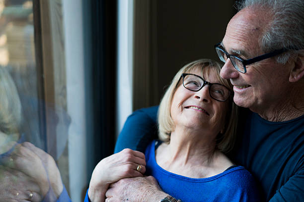 istock Smiling senior woman looking at man by window 541584236