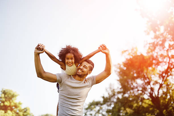 vater tragen tochter huckepack nehmen - family summer portrait nature stock-fotos und bilder