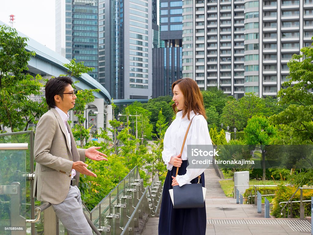 Japanese man and woman commuting to work in the street. 25-29 Years Stock Photo