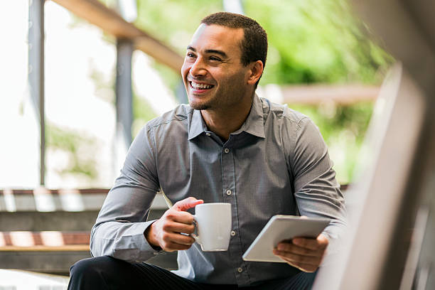 Businessman with mug and digital tablet on steps