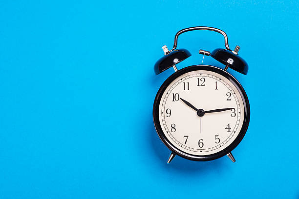 istock Old vintage alarm clock standing on the blue surface 541586690