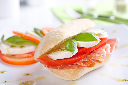 Tomato and Mozzarella Sandwich with fresh basil leaves