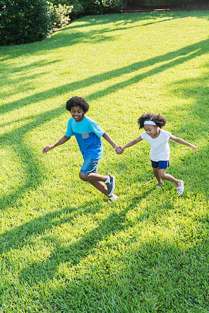 istock Mixed race brother and sister playing in park 541587256