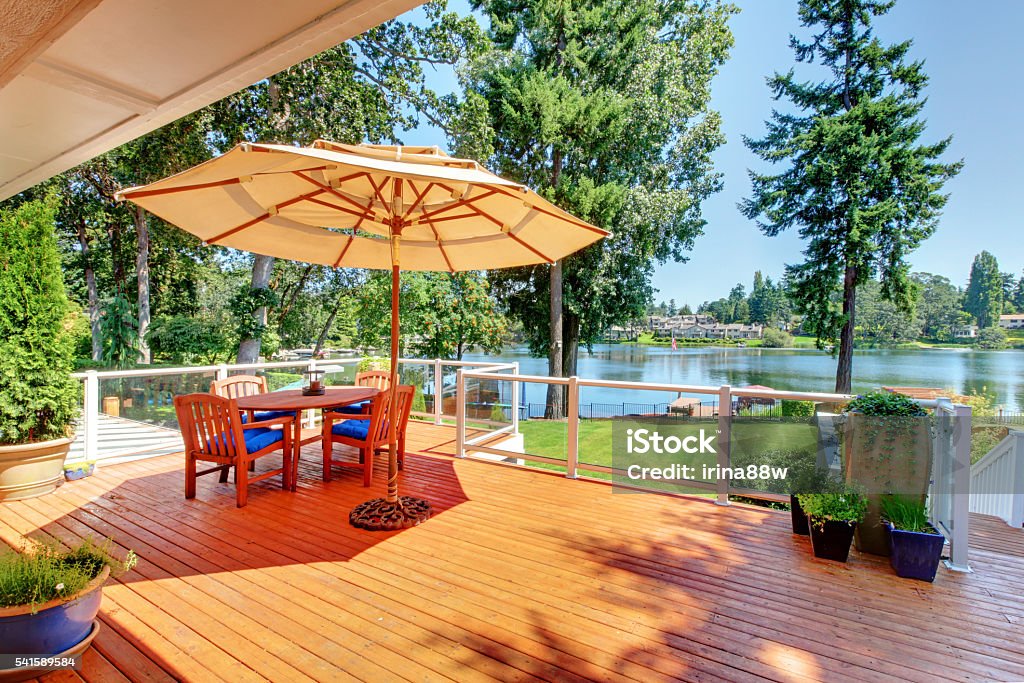 Sitting room area on screened walkout deck with patio table Sitting room area on walkout deck with patio table, umbrella and chairs overlooking water view. Architecture Stock Photo