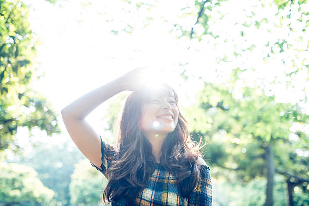 太陽の下で楽しいひとときを - 若い女性一人 ストックフォトと画像