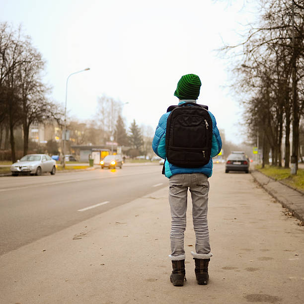 istock schoolboy alone in the street 541593172