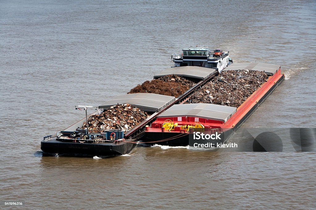 Two barges loaded with metal scrap Two barges loaded with metal scrap on the river Barge Stock Photo