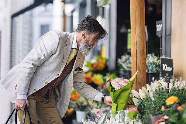 Mature man buying flowers in flower shop French mature man buying flowers in flower shop at Paris. man flower stock pictures, royalty-free photos & images