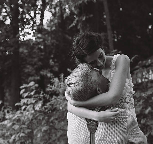 istock groom holds bride in his arms 541602032