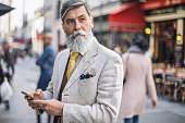Bearded mature man texting at the street