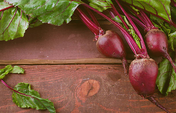 istock Organic young beets with green leaves on wooden table 541607176