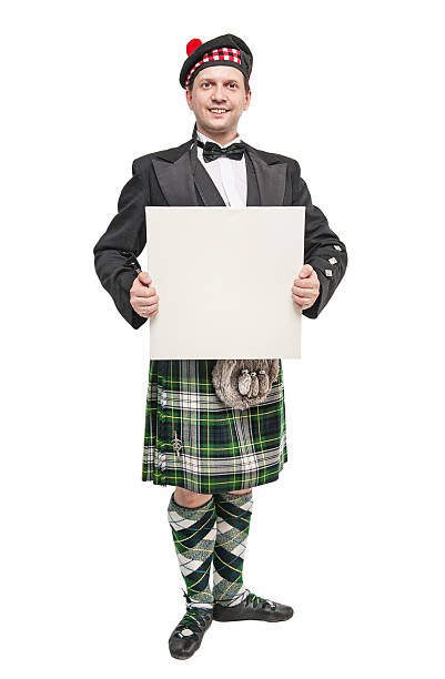 istock Scottish man in traditional national costume with empty banner 541609410