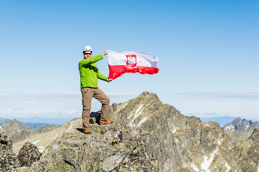 Hiker manifests the joy of Polish flag at the top.
