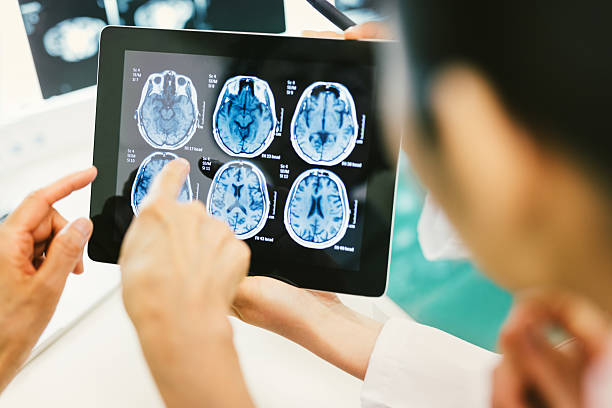 medico e paziente utilizzando tavoletta digitale in ospedale - radiologist computer doctor mri scan foto e immagini stock