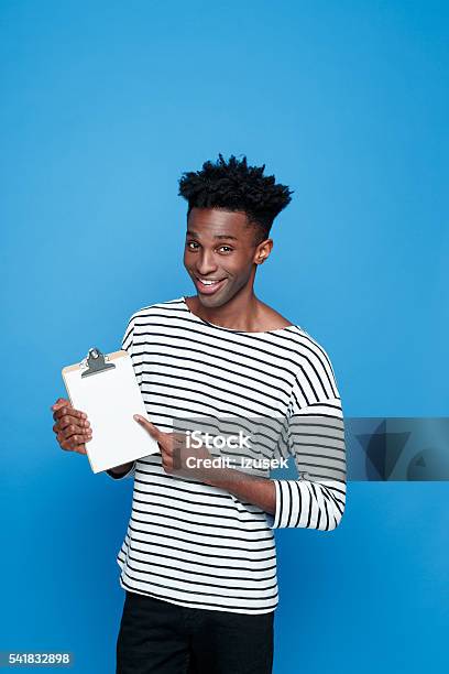 Happy Afro American Holding Clipboard Stock Photo - Download Image Now - African-American Ethnicity, Blue Background, Clipboard