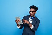 Excited afro american guy in fashionable outfit, holding digital tablet