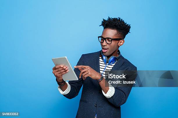 Excited Afro American Guy In Fashionable Outfit Holding Digital Tablet Stock Photo - Download Image Now