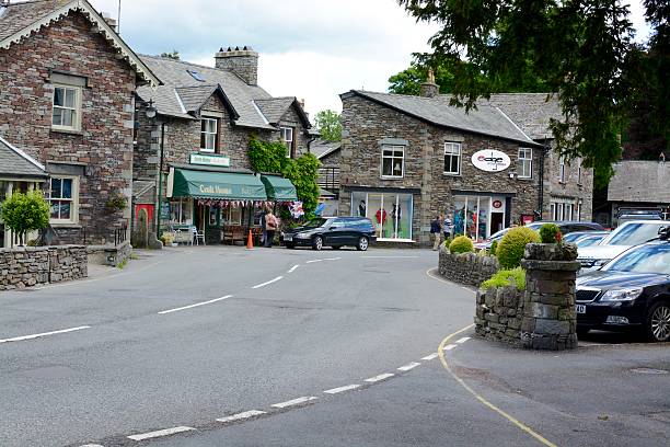 Grasmere Village Grasmere, United Kingdom - June 20, 2016: The beautiful village of Grasmere, in the central lake district, 4 people can be seen walking in the village Grasmere, Cumbria, UK  grasmere stock pictures, royalty-free photos & images