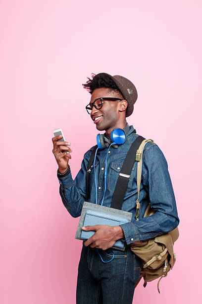 afro-americana, usando um telefone inteligente aluno - men smiling headphones individuality - fotografias e filmes do acervo